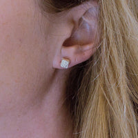 A pair of Cube studs, each carrying a piece of handwritten script — Clustdlysau Arian