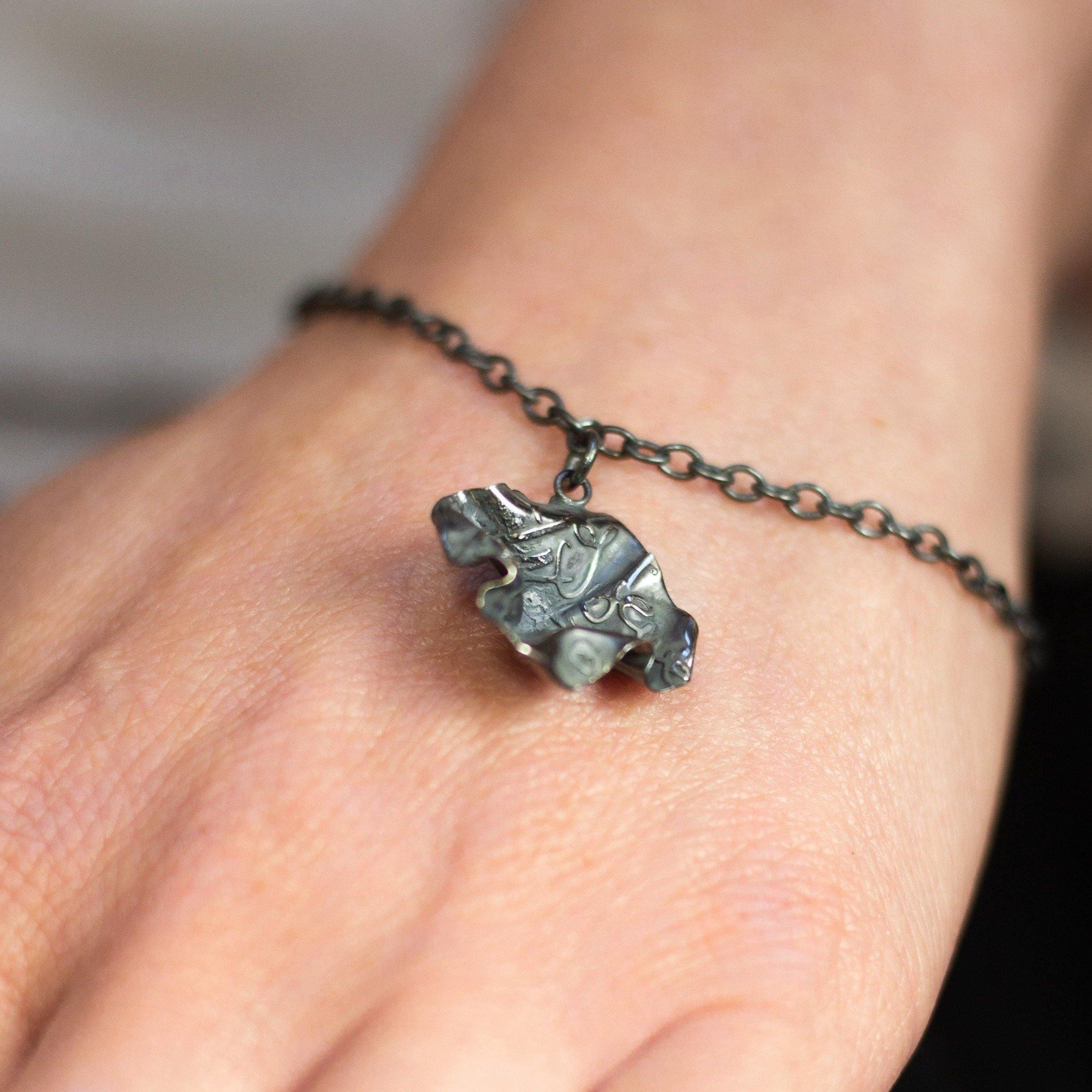 Decorative Concepts charm bracelet in black oxidised silver, close-up detail