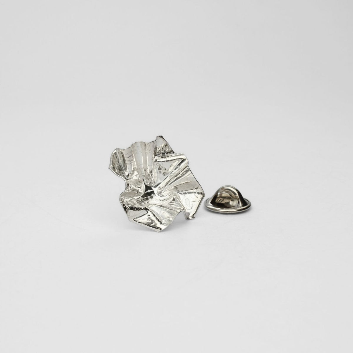 Decorative Concepts lapel pin, sterling silver — a considered mark drawn from paper