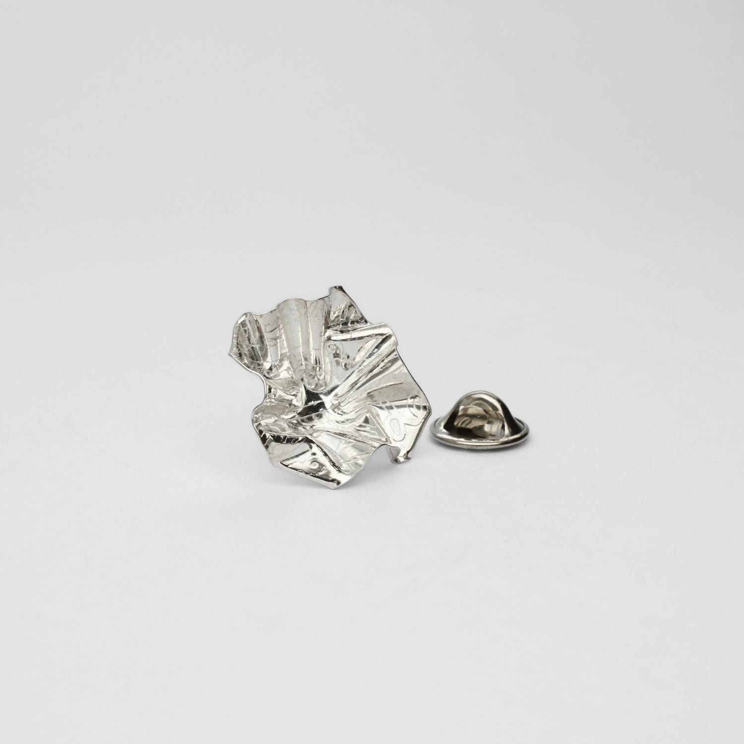 Decorative Concepts lapel pin, sterling silver — a considered mark drawn from paper