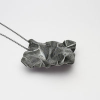 Close-up on the writing etched into a Decorative Concepts large black pendant — Mwclis Arian