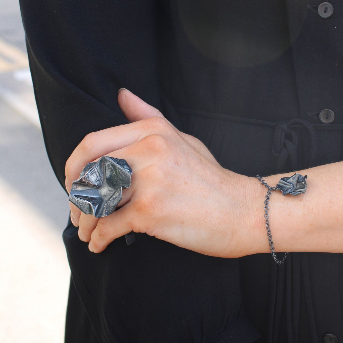 Decorative Concepts large statement ring and charm bracelet in black oxidised silver, shown on model