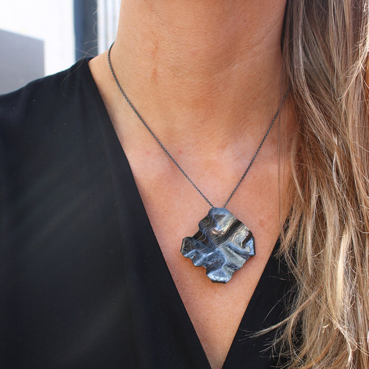 Decorative Concepts medium pendant in black oxidised silver, shown on model