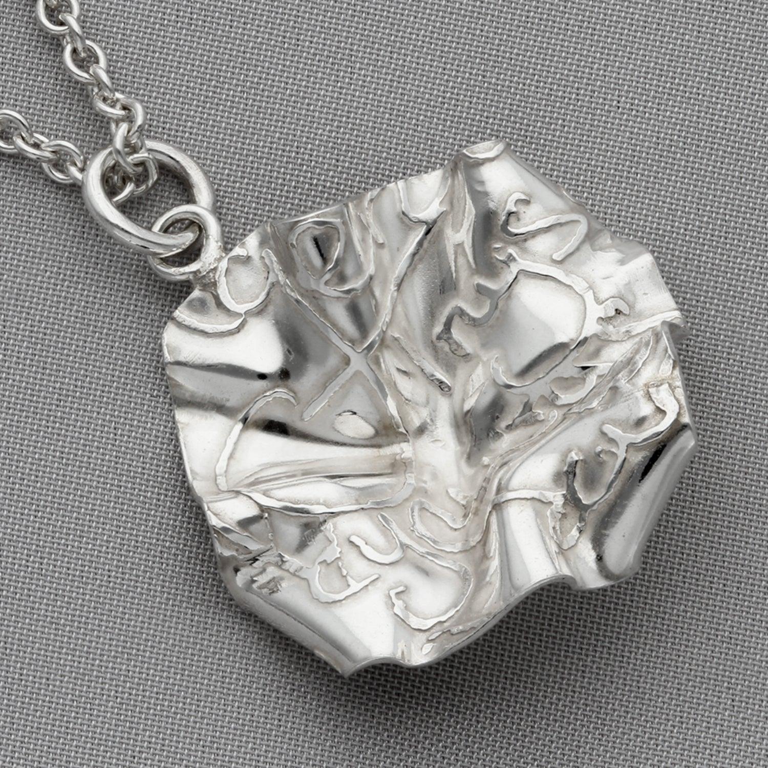 Side profile of the Decorative Concepts pendant, inspired by a page of handwriting — Mwclis Arian