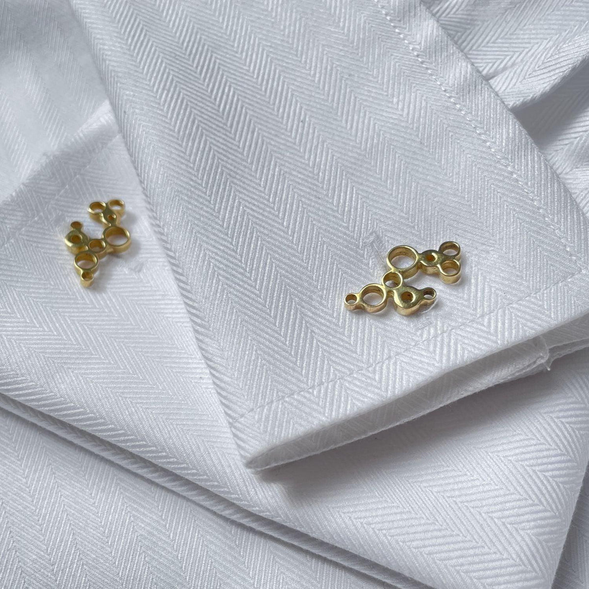 Side view of the Golden Bubbles cufflinks, celebration-themed design — Botymau Coesau Aur