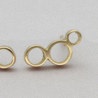Close-up on the clustered circles of a Golden Bubbles stud, echoing bubbles in a glass — Clustdlysau Aur