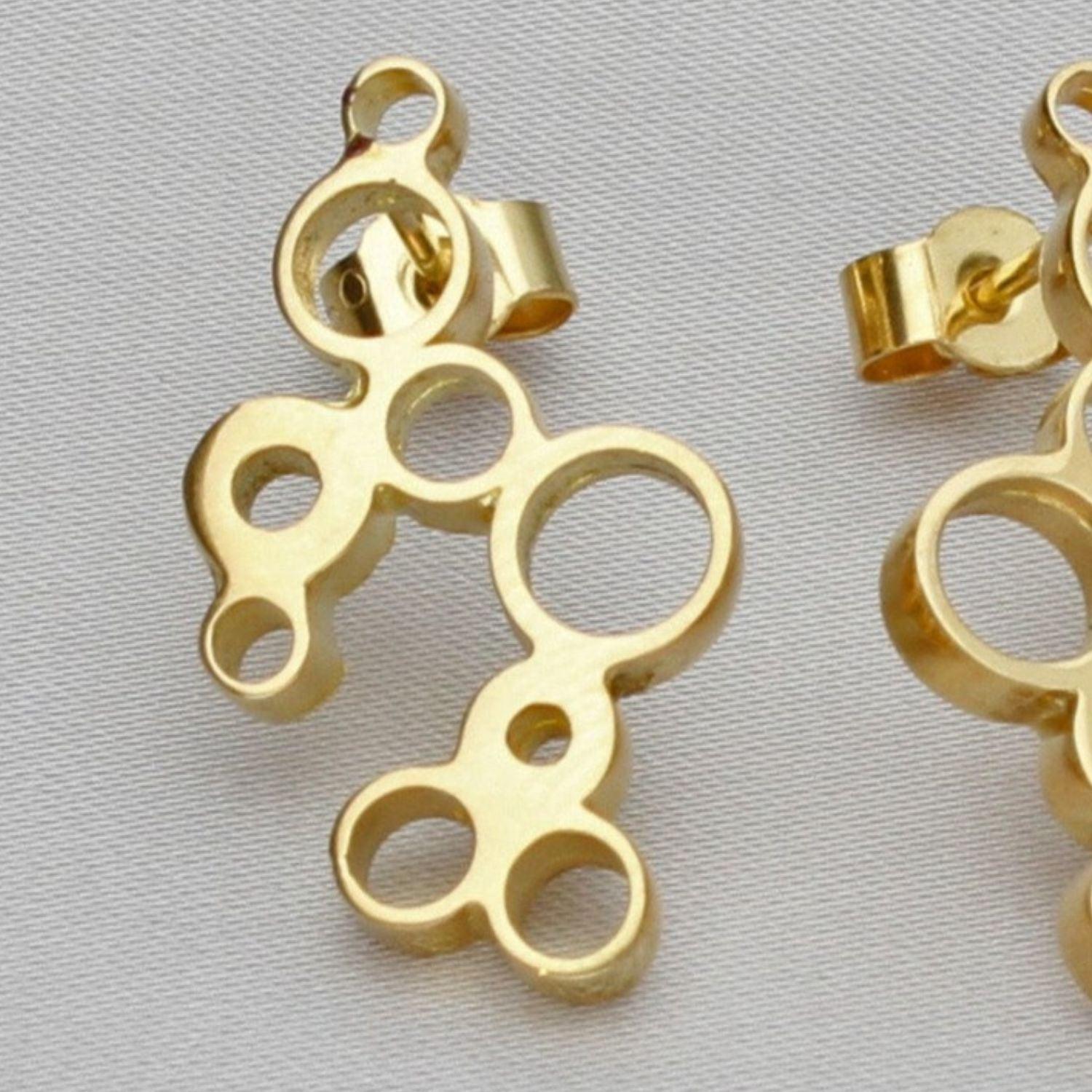 Close-up on the Golden Bubbles earring's clustered circles, echoing bubbles in a glass — Clustdlysau Aur